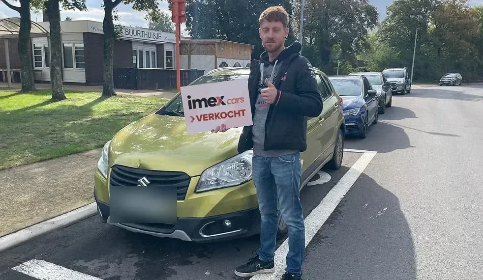 Verkoper met Imex Cars ‘VERKOCHT’ bord bij verkochte auto, verkoop je auto in België