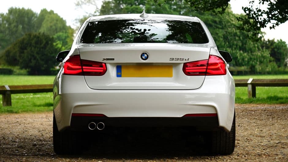 Witte BMW 335d van achteren op een grindpad in een park